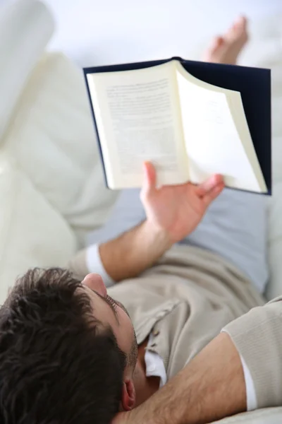 Homem no sofá livro de leitura — Fotografia de Stock