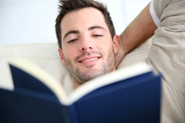 Hombre en libro de lectura de sofá — Foto de Stock