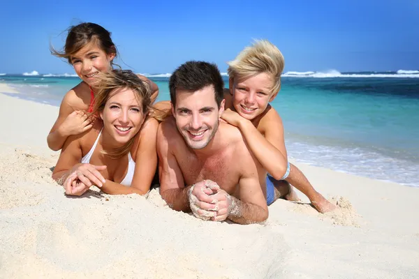 Família deitada na praia — Fotografia de Stock