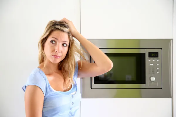 Woman by microwave oven — Stock Photo, Image