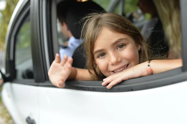 Ragazza che sventola mano dalla finestra della macchina — Foto Stock