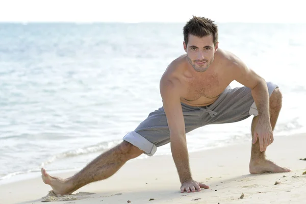 Man stretching on the beach — Stock Photo, Image