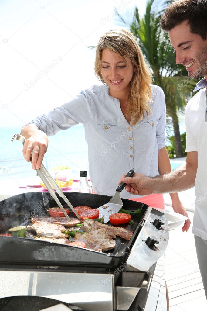 Couple preparing grilled food