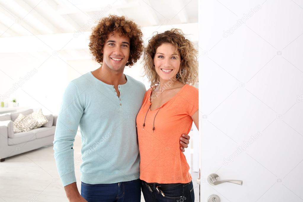 Smiling couple opening door