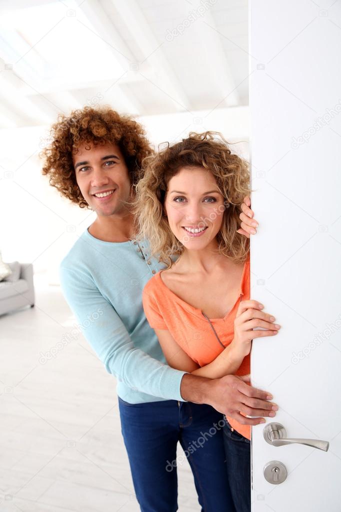 Smiling couple opening door