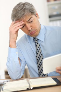 Tablet üzerinde çalışan iş adamı