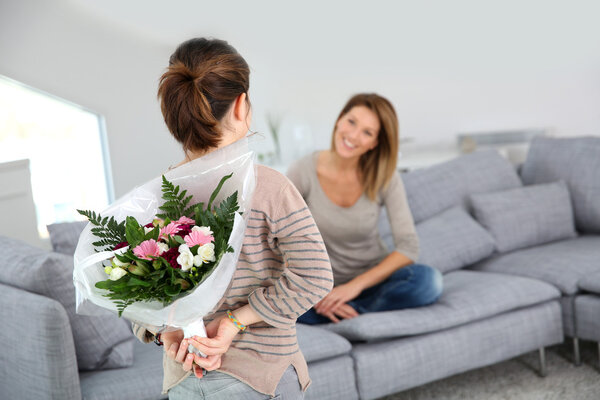 Девочка дарит цветы маме
