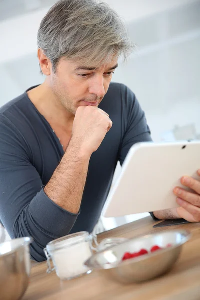 Mann schaut auf digitales Tablet — Stockfoto