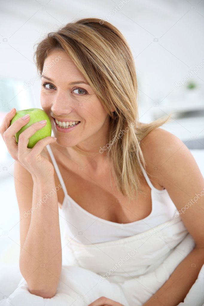Woman giving bite to apple