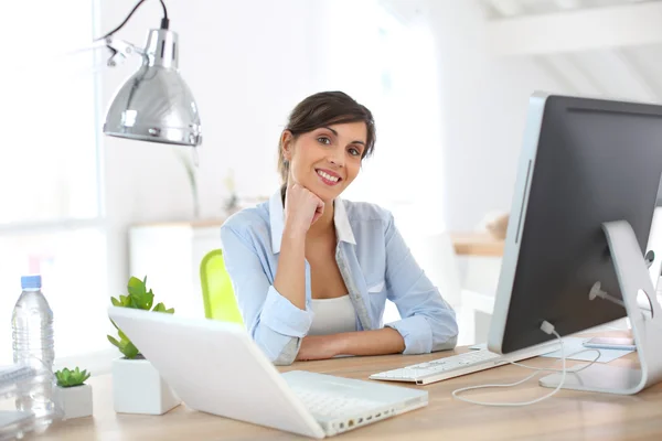 Büroangestellte sitzt am Schreibtisch — Stockfoto