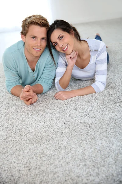 Couple laying on carpet floor — Stock Photo, Image