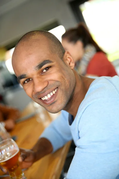 Smiling man sitting in snack bar — Stock Photo, Image