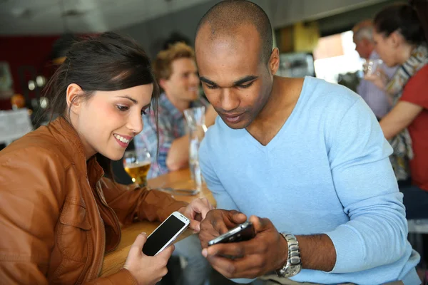 Mensen in koffie winkel met behulp van smartphones — Stockfoto