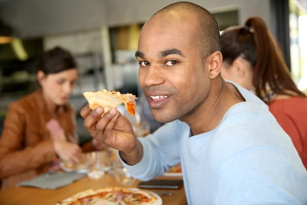 Hombre comiendo rebanada de pizza — Foto de Stock