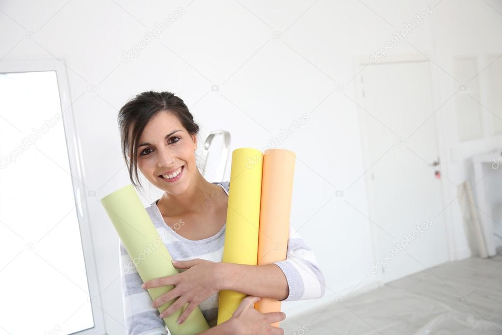 Girl holding wallpaper rolls