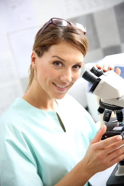 Doctor looking through microscope — Stock Photo, Image