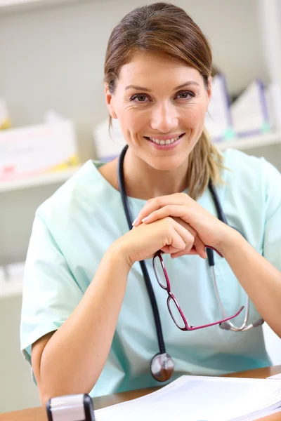 Sjuksköterska i office håller glasögon — Stockfoto