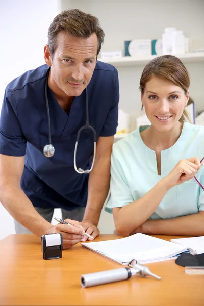 Doctor signing prescription — Stock Photo, Image