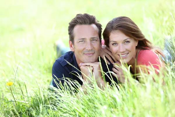 Lovely couple lying in field — Stock Photo, Image