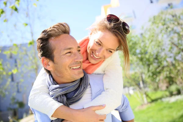 Homem dando piggyback passeio para mulher — Fotografia de Stock