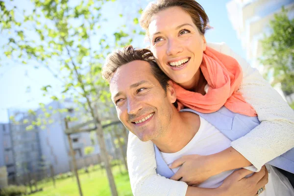 Man giving piggyback ride in park — Stock Photo, Image