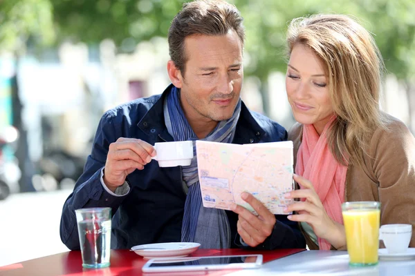 Turistas com mapa em cafeteria — Fotografia de Stock
