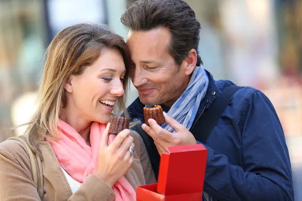 Lovely couple eating caneles — Stock Photo, Image