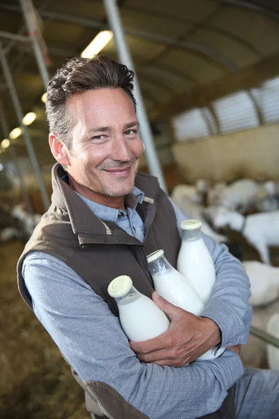 Agricultor segurando garrafas de leite — Fotografia de Stock