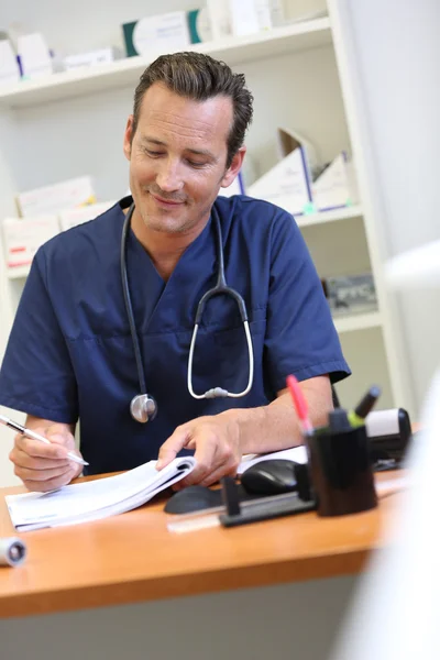 Médico que escreve prescrição médica — Fotografia de Stock