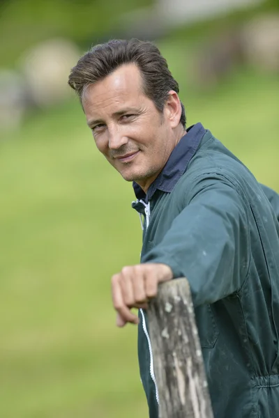 Smiling farmer leaned on fence — Stock Photo, Image