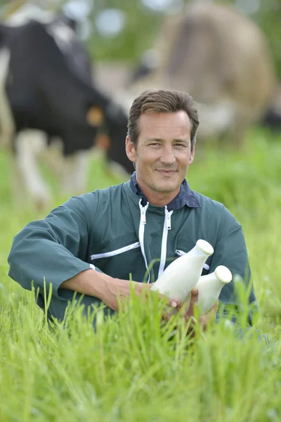 Agricultor sosteniendo botellas de leche — Foto de Stock