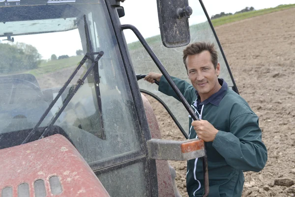 Granjero subiendo al tractor — Foto de Stock