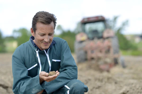 Farmer checking on ground — Stock Photo, Image