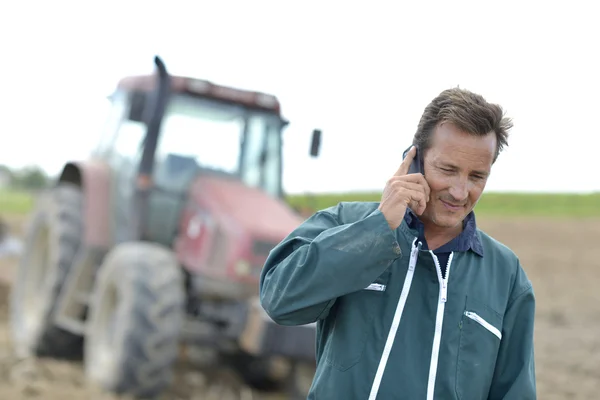 Agricultor com telefone em campo — Fotografia de Stock