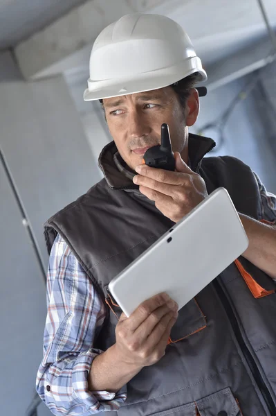 Entrepreneur using walkie-talkie and tablet — Stock Photo, Image