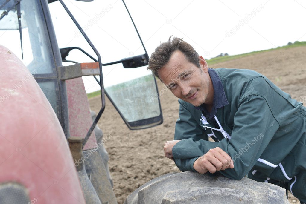 Farmer leaning on tractor