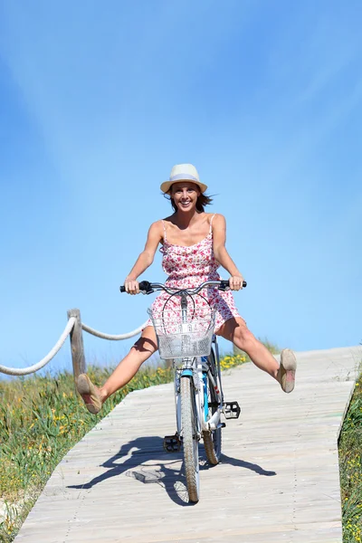 Girl riding bicycle by beach — Stock Photo, Image