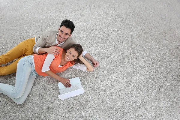 Pareja sobre alfombra usando tableta —  Fotos de Stock