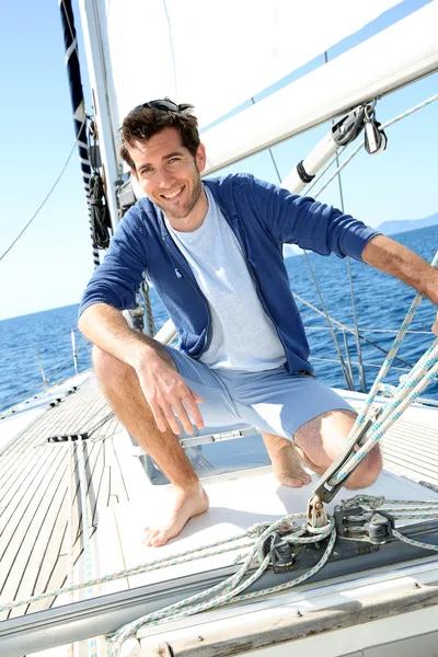 Man on sailboat Stock Picture