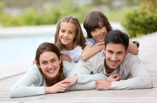 Familie am Pool liegend — Stockfoto