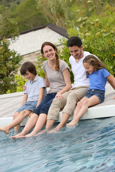 Famiglia rilassante a bordo piscina — Foto Stock