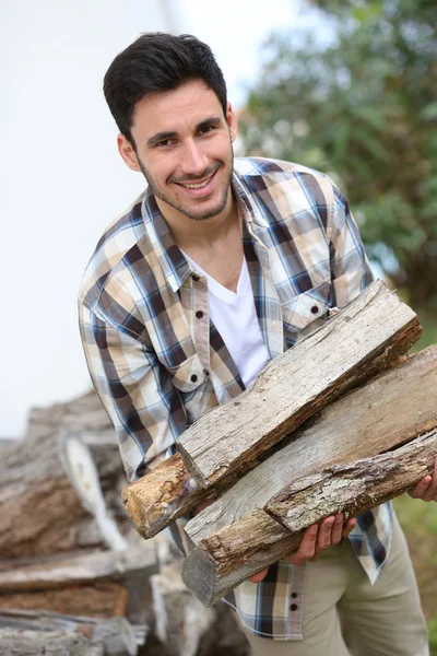 Man met houten logboeken — Stockfoto