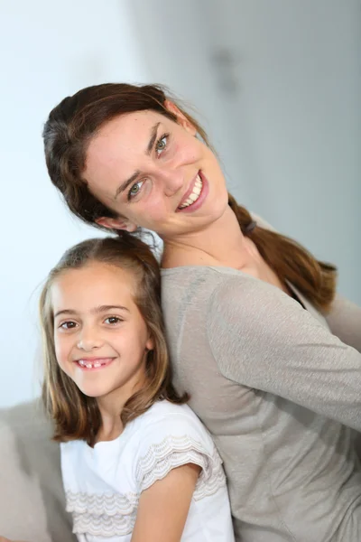 Mutter und Tochter sitzen Rücken an Rücken — Stockfoto