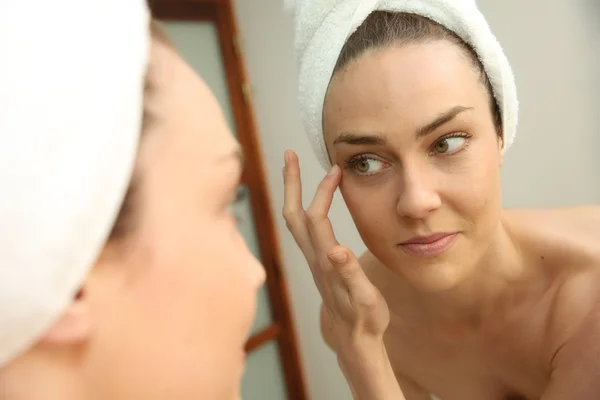 Woman looking in mirror — Stock Photo, Image