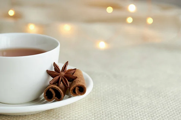 Biała Filiżanka Herbaty Cynamonem Beżowej Kratę Lampkach Świątecznych Boże Narodzenie — Zdjęcie stockowe