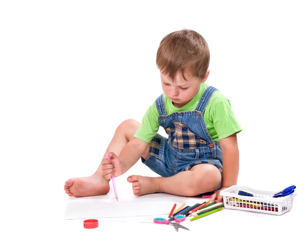 Menino desenha um lápis sentado no chão — Fotografia de Stock