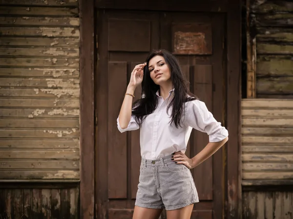 Mode jolie jeune femme posant en plein air près d'un vieux mur en bois — Photo