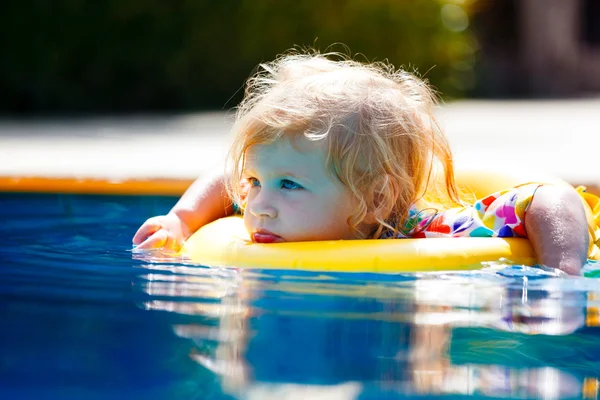 Petit bébé nageant dans une piscine sur l'anneau de natation — Photo