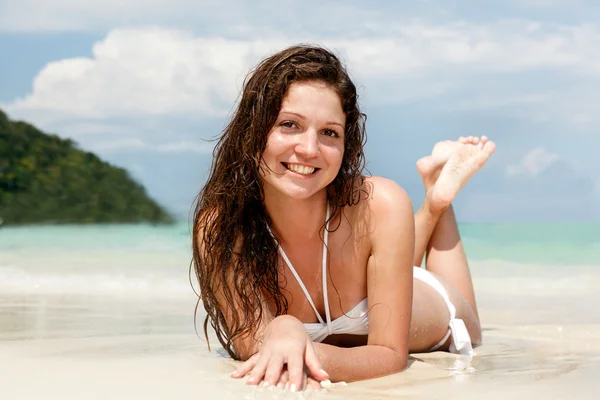 Portret van een gelukkige jonge vrouw poseren terwijl op het strand — Stockfoto