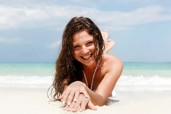 Portret van een gelukkige jonge vrouw poseren terwijl op het strand — Stockfoto